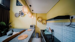 Una cocina compacta con horno integrado, un lavamanos y una encimera con un tostador.