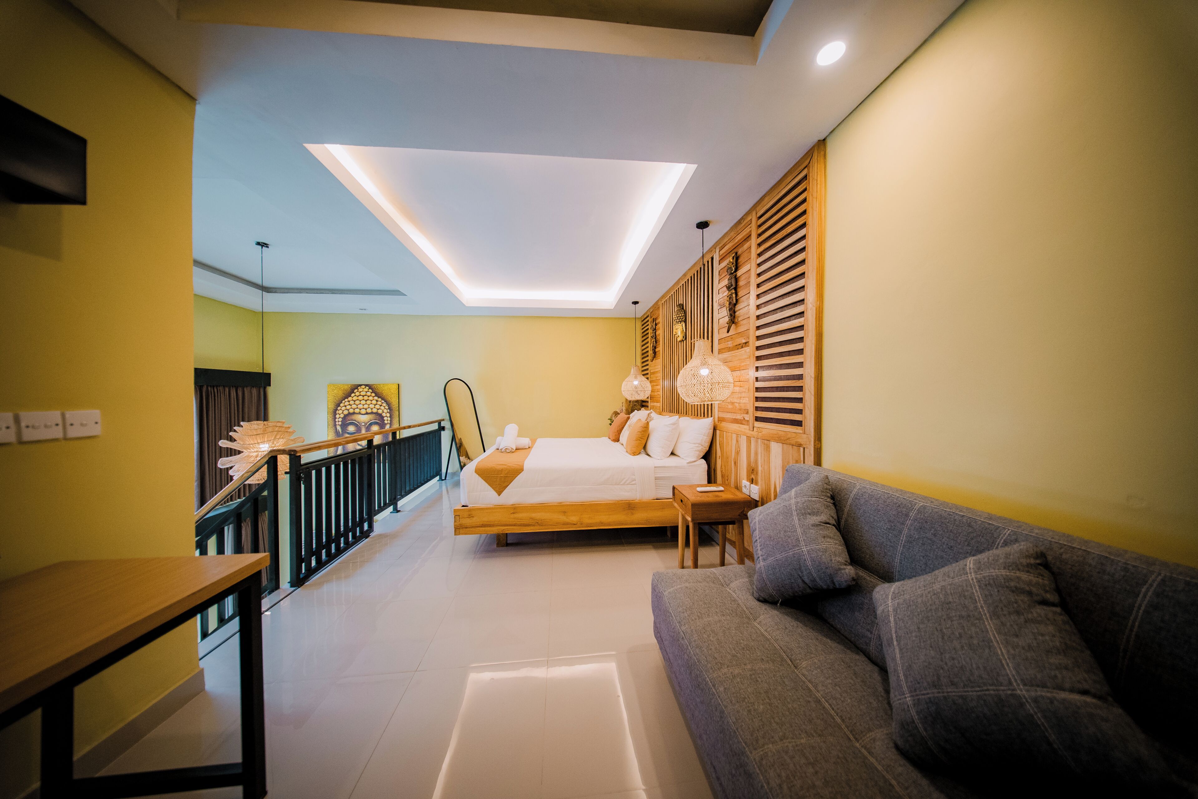 A modern bedroom with a bed, a sofa, and a staircase.