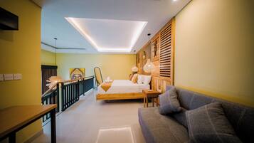 A modern bedroom with a bed, a sofa, and a staircase.