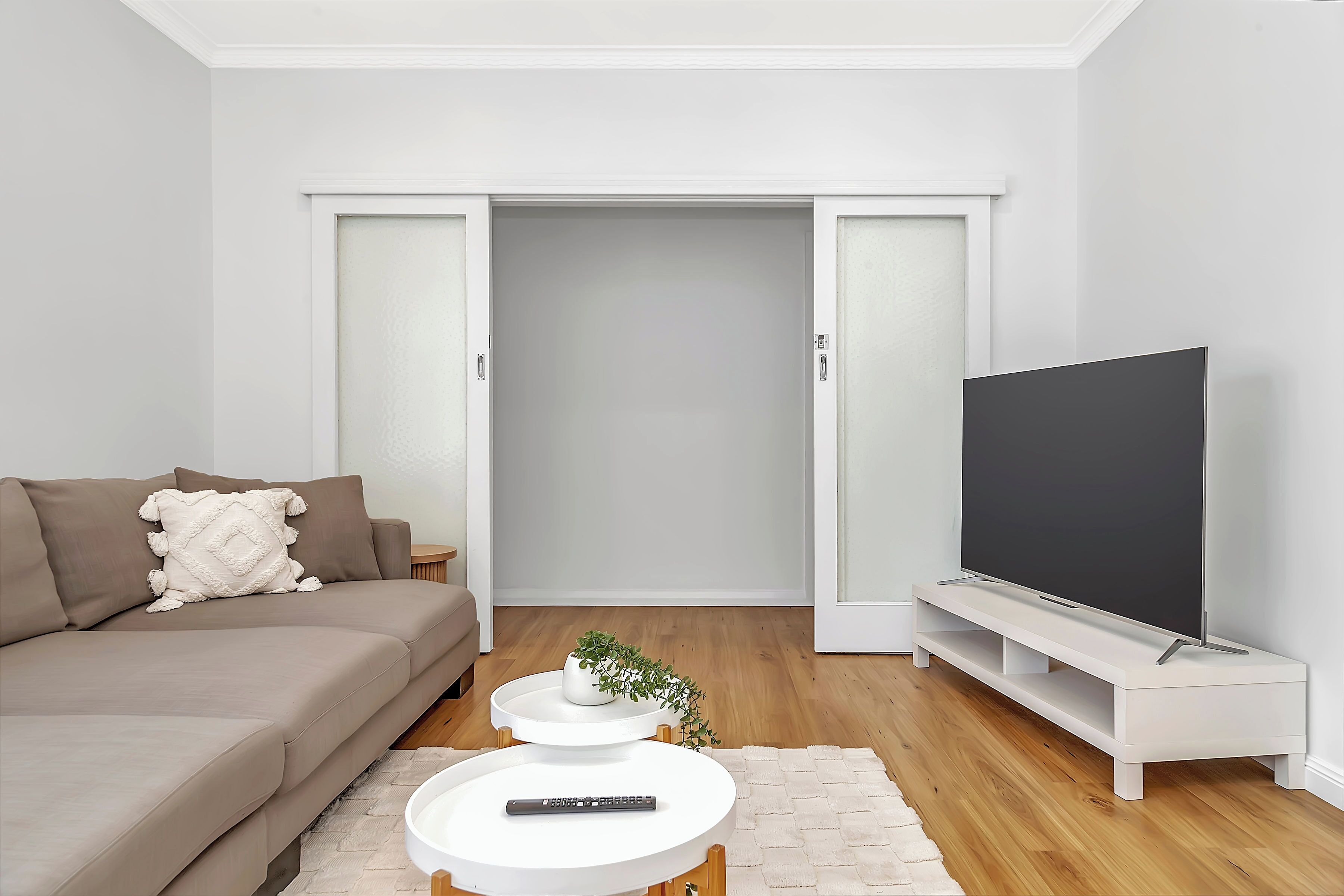 Una sala de estar moderna con un sofá, un televisor de pantalla plana y una mesa de centro.