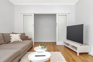 Una sala de estar moderna con un sofá, un televisor de pantalla plana y una mesa de centro.