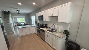A modern kitchen with white cabinets, stainless steel appliances, and a marble countertop. - Sleeps 15, 5BR, 2 Blocks to Convention Center & Beach, 2 Parking Spots (Wildwood)
