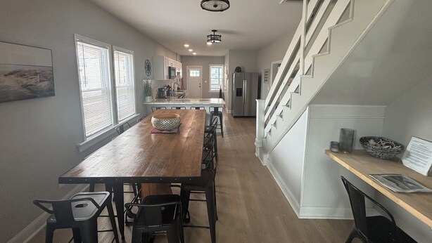 A modern kitchen with a wooden island, a dining area with chairs, and a staircase leading to another level. - Sleeps 15, 5BR, 2 Blocks to Convention Center & Beach, 2 Parking Spots (Wildwood)