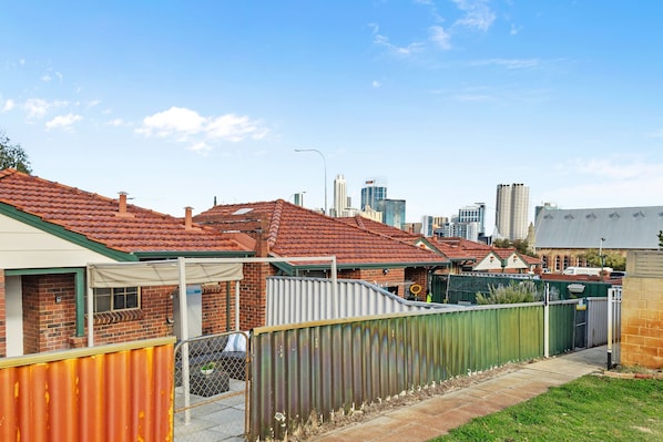 A row of terraced houses with a city skyline in the background. - The Finch Fern A Sepal Stay (Perth)