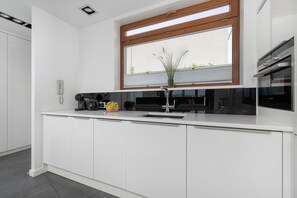 Una cocina moderna con horno empotrado, un fregadero y una ventana sobre la encimera.