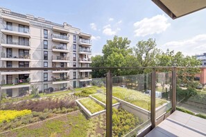 A modern apartment building with multiple balconies, a rooftop garden, and a clear view of the surrounding area. - Cozy Studio Near the Wisla River | Balcony | Zabłocie (Kraków)