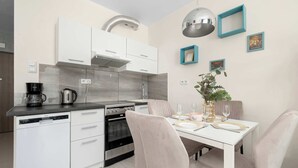 Eine moderne Küche mit weißen Schränken, einem eingebauten Backofen und einer Kaffeemaschine.