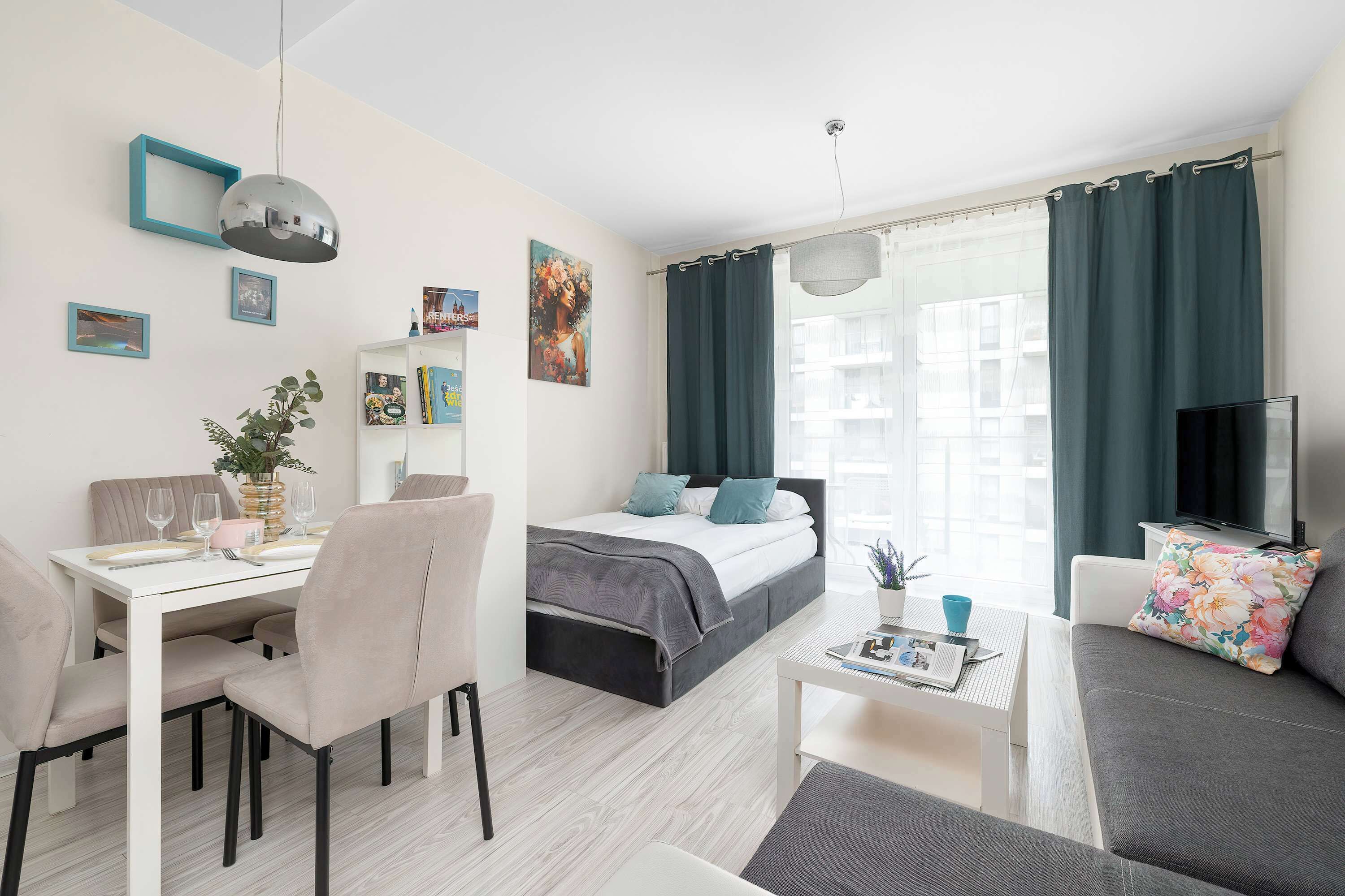 A modern, well-lit room with a bed, a dining area, and a seating area.