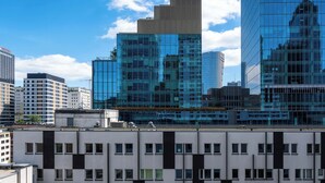 Ein modernes Hochhaus mit spiegelnden Glasfenstern, umgeben von weiteren Gebäuden.
