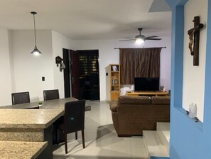 A living room with a television, sofa, and a dining area with chairs and a table. - HOUSE WITH A ROOF GARDEN IN A PRIVATE RESIDENTIAL COMPLEX WITH 24/7 SECURITY AND ACCESS CONTROL (Guadalupe)