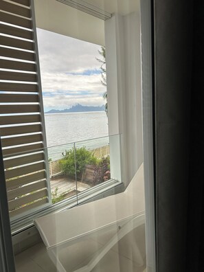 A balcony with a view of the sea and mountains.