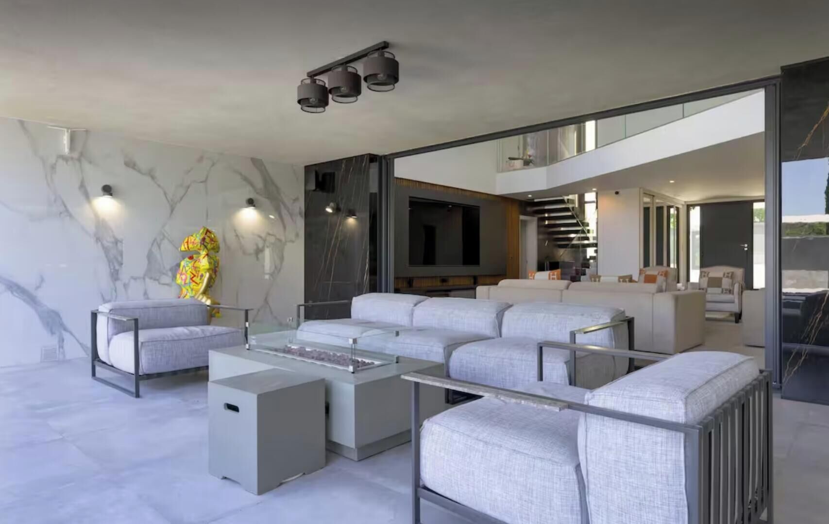 Un salon moderne avec un canapé d’angle, une table basse et un téléviseur à écran plat.