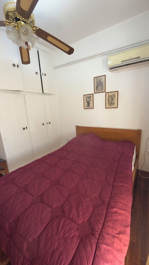 A bedroom with a bed, a ceiling fan, an air conditioning unit, and a wardrobe. - Quiet summer / winter house near Athens (Agioi Theodoroi)