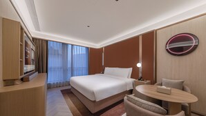 A hotel room with a bed, bedside table, chair, and a television. - Crystal Orange Tianjin Eye Ancient Culture Street (Tianjin)