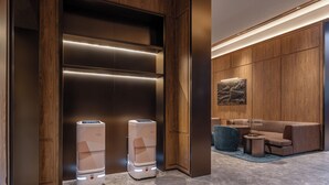 A modern interior with two water dispensers, a wooden panel wall, and a seating area with a blue ottoman. - Crystal Orange Tianjin Eye Ancient Culture Street (Tianjin)