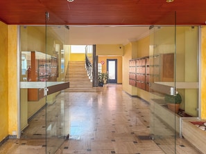 A hallway with glass doors, a staircase, and lockers. - Renovated 1BR | Steps from Croisette & Beach (Cannes)