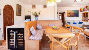 Una cocina acogedora con un banco de madera, una mesa de comedor y un enfriador de vino.