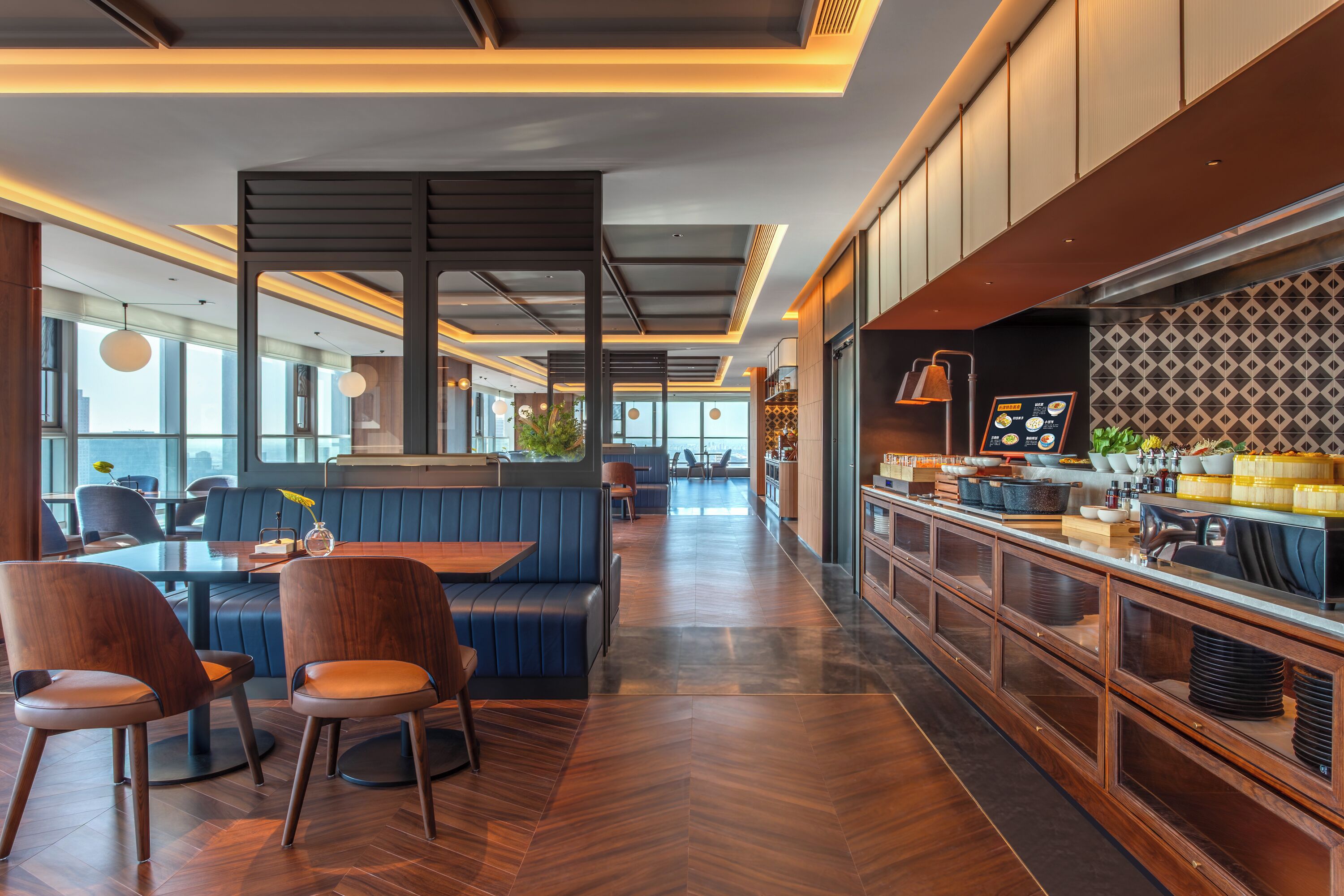 Un interior de restaurante moderno con una barra, asientos y vistas amplias a través de grandes ventanales.