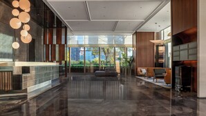 A modern lobby with a reception desk, seating area, and large windows offering a view of the outdoors. -  IntercityHotel Tianjin Binhai Yujiapu Financial District (Tianjin)