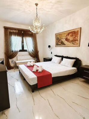 Un dormitori d'hotel amb un llit, escriptori, cadira, radiador i un quadre a la paret.