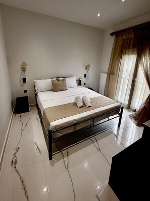 A modern bedroom with a large bed, bedside lamps, a radiator, and a window with curtains. - Moonlit Olives - Corfu Luxurious & Stylish Escape (Kokkinogia)