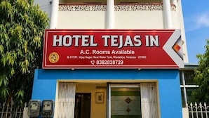 Ein Schild mit der Aufschrift 'HOTEL TEJAS IN' und 'A.C. Zimmer verfügbar', das Name und Ausstattung des Hotels angibt.