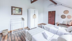 A bedroom with two beds, a wardrobe, a radiator, and a wooden ceiling.