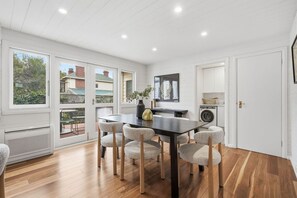A modern kitchen with a dining area, large windows, and a view of the outside. - South Hobart Designer Retreat (South Hobart)