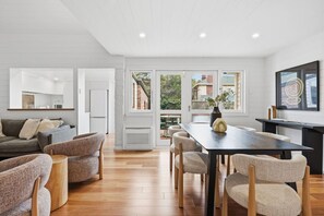 A modern living room with a dining area, wooden flooring, and a view of the outside. - South Hobart Designer Retreat (South Hobart)