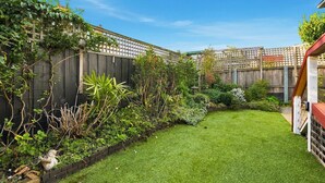 A well-maintained garden with a variety of plants and a neatly trimmed lawn. - South Hobart Designer Retreat (South Hobart)