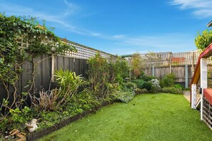 Ein gepflegter Garten mit vielfältigen Pflanzen und einem ordentlich gestutzten Rasen.