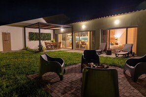 An outdoor patio area with seating and a fire pit. - Guestready - Casa do Lanceiro by Cavalhadas House (Ribeira Grande)