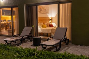 Une chambre d’hôtel avec un lit, deux fauteuils, une petite table et une vue sur l’intérieur.