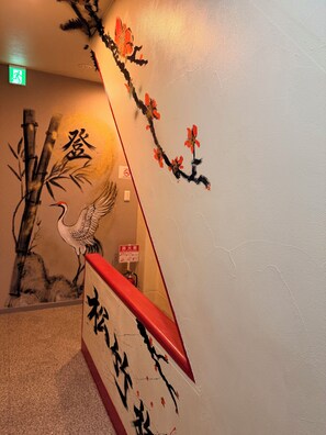 A wall with traditional artwork, a red object, and a sign with Chinese characters. - To-Fu-rou (Osaka)
