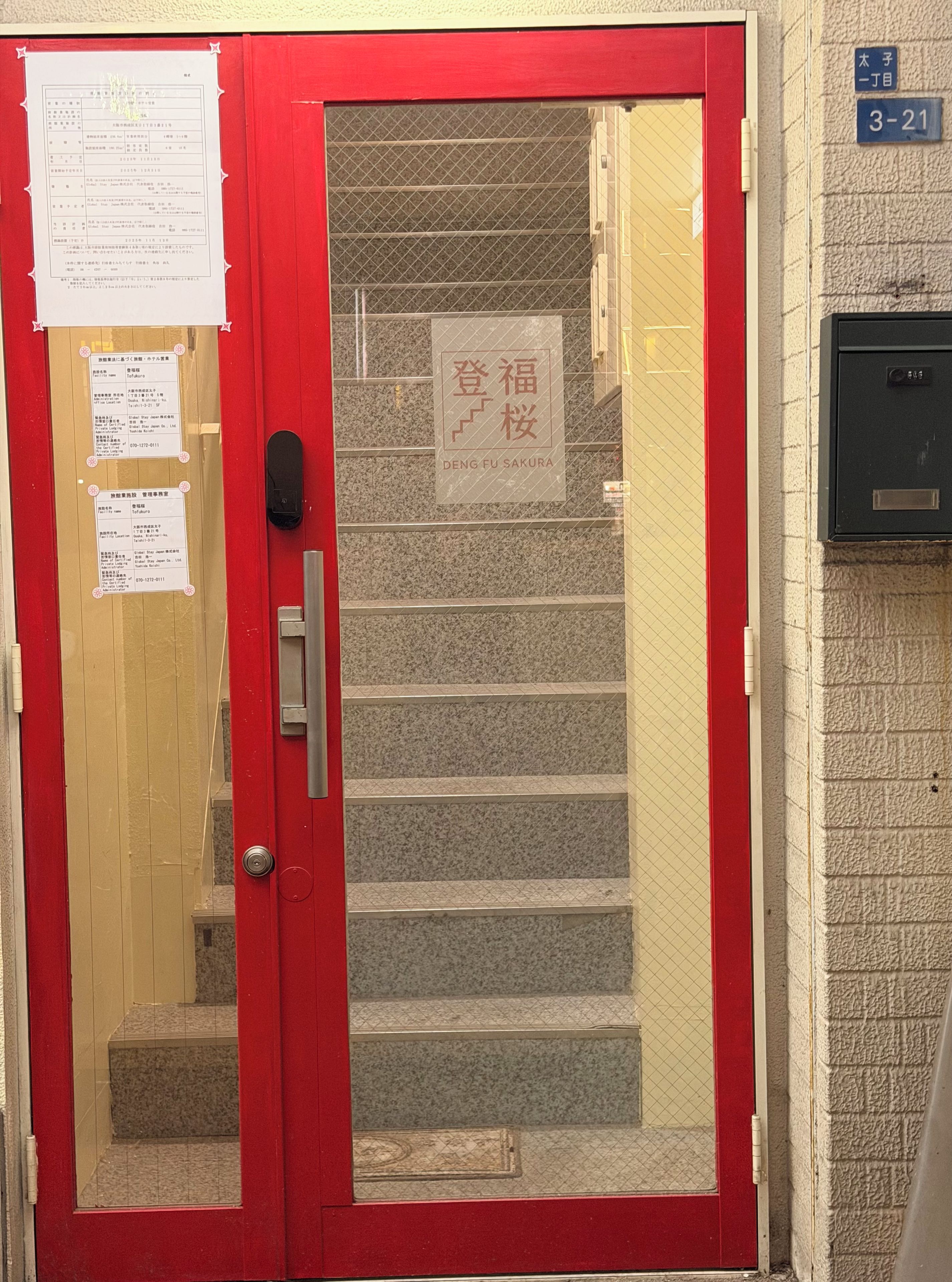 Una puerta roja con un panel de vidrio, una escalera y un letrero que dice 'DENG FU SAKURA'.