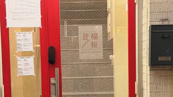 Una puerta roja con un panel de vidrio, una escalera y un letrero que dice 'DENG FU SAKURA'.