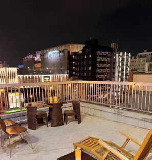 A rooftop terrace with outdoor seating and a city view at night. - To-Fu-rou (Osaka)