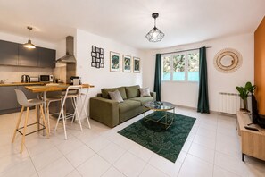 Ein modernes Apartment mit Küche, Essbereich und Wohnbereich.