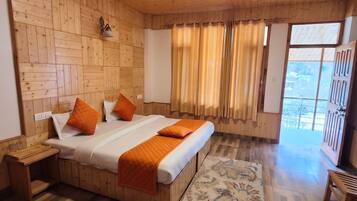 A wooden-paneled room with a bed, a small table, and a view through a window.
