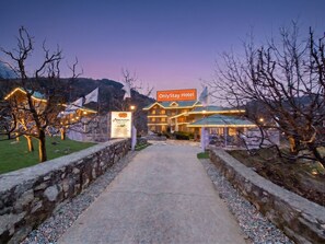 A hotel entrance with a sign for 'OnlyStay Hotel' and a sign for 'Povinnman Resort'. - OnlyStay Persimmon Farmstead (Manali)