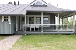 A single-story building with a covered porch, a door, and a small window. - Kivakka C 6 | 2BR Cabin near Lake | 2 Ski Passes (Kuusamo)