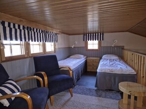 A compact room with two beds, a chair, a small table, and a window. - Kivakka C 6 | 2BR Cabin near Lake | 2 Ski Passes (Kuusamo)