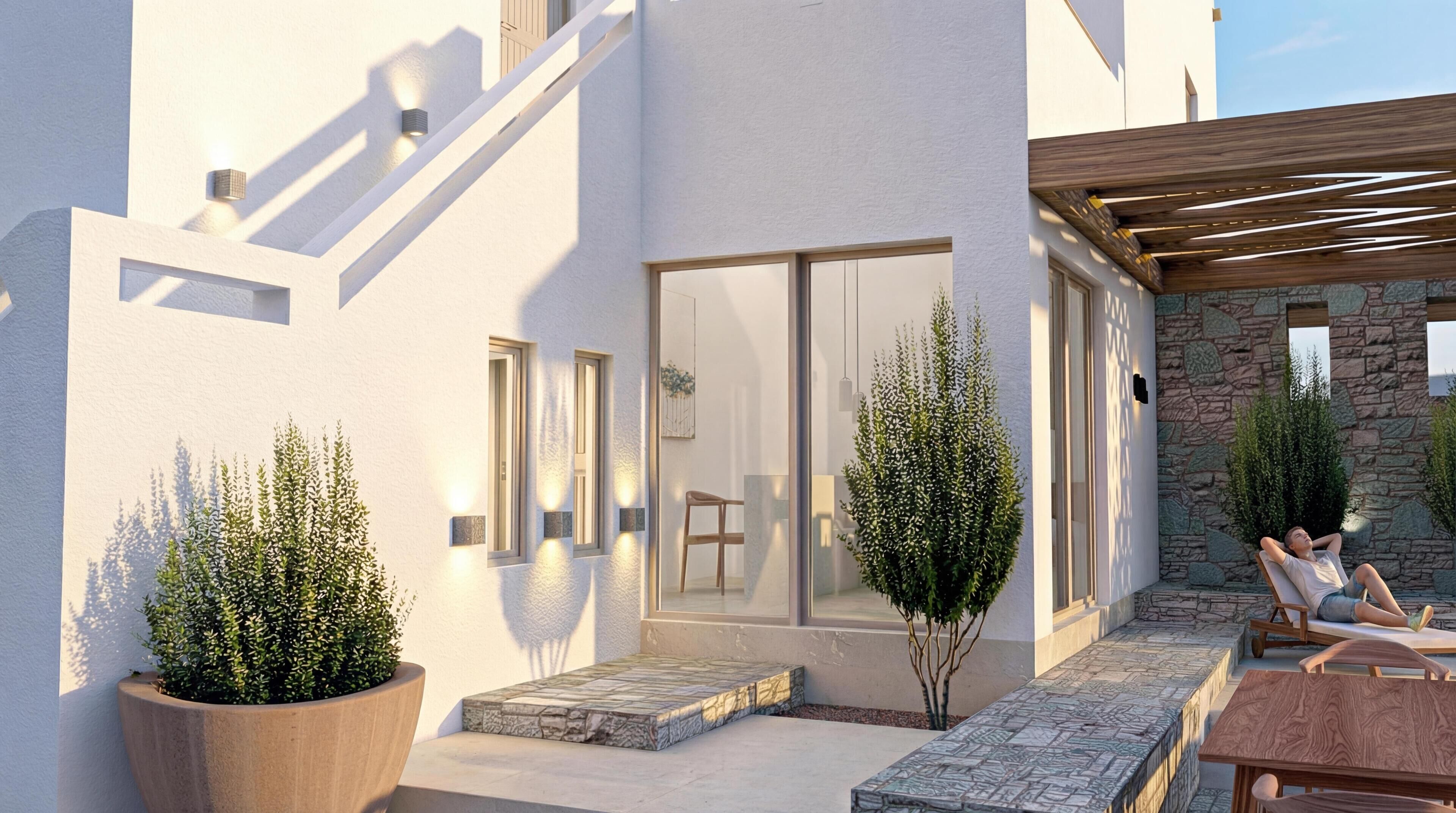 A modern building with a covered patio area, outdoor seating, and potted plants.