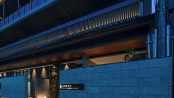 A modern hotel entrance with a sign for 'Anran Hotels & Resorts,' a covered walkway, and a landscaped area with plants.