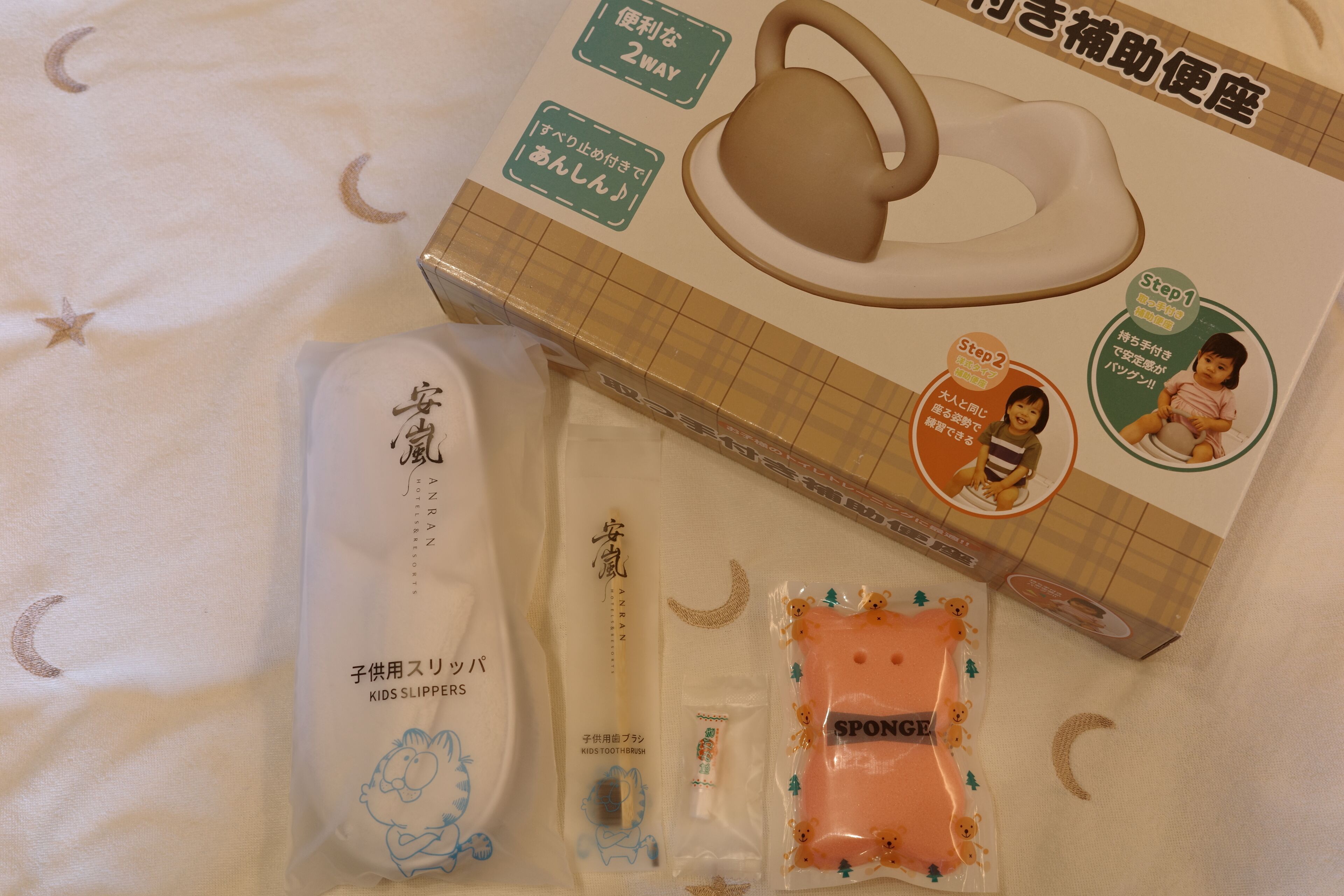 A package with a children's toothbrush, a sponge, and a pair of slippers.