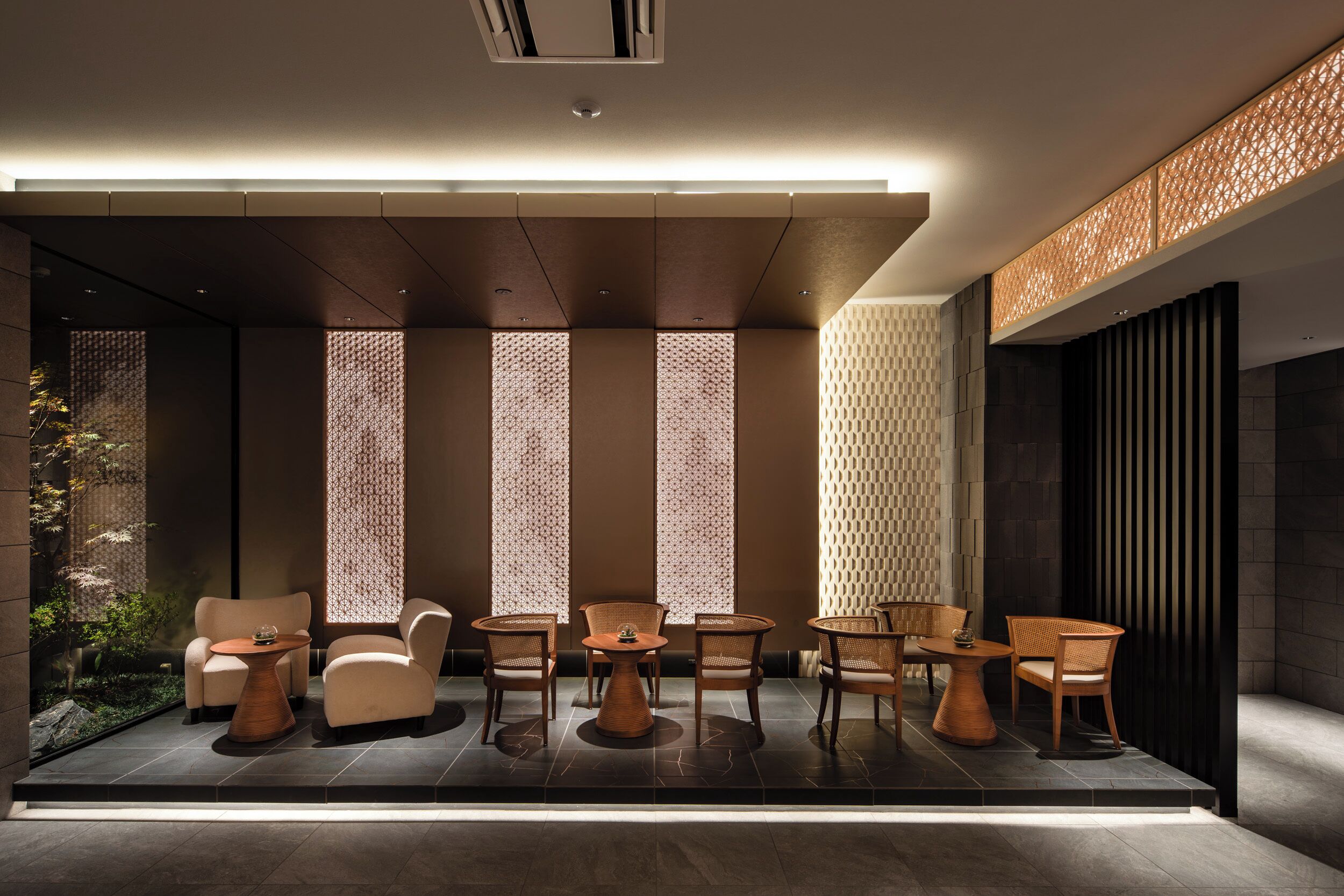 A modern interior with a seating area, patterned walls, and a ceiling light.