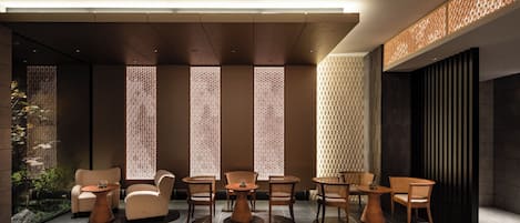 A modern interior with a seating area, patterned walls, and a ceiling light.