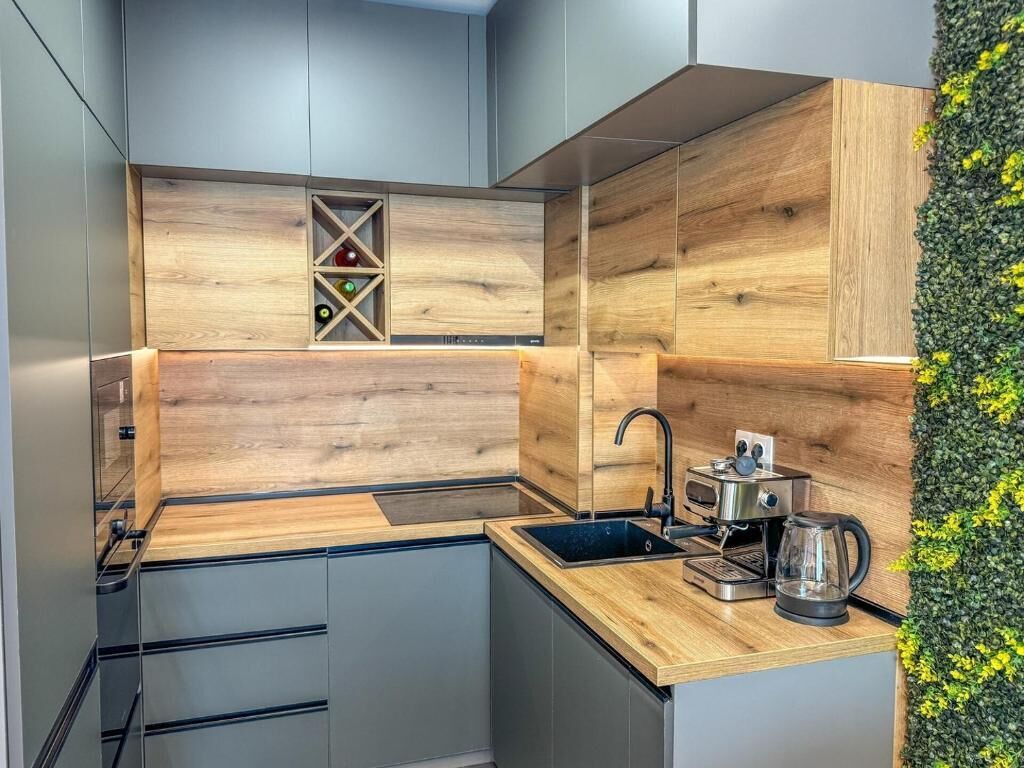 Une cuisine moderne avec des meubles en bois, un meuble-bar intégré et une machine à café.