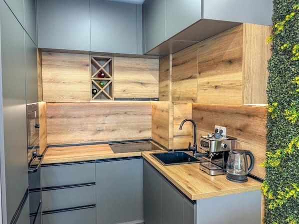 A modern kitchen with wooden cabinetry, a built-in wine rack, and a coffee maker.