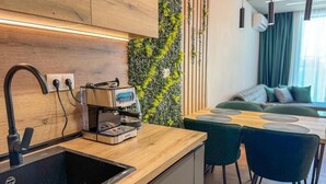 Uma cozinha moderna com cafeteira embutida, pia e área de refeições com mesa e cadeiras.